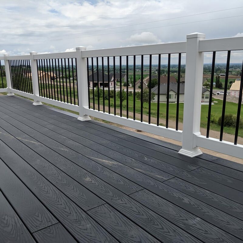 Transform your backyard into a sophisticated outdoor retreat with our signature elevated Carbon Plank Panorama, a low-maintenance near-black charcoal composite deck custom-designed by the specialists at DeckPro LLC. This stunning, expansive multi-level raised platform features a safe and modern high-contrast hybrid railing system.