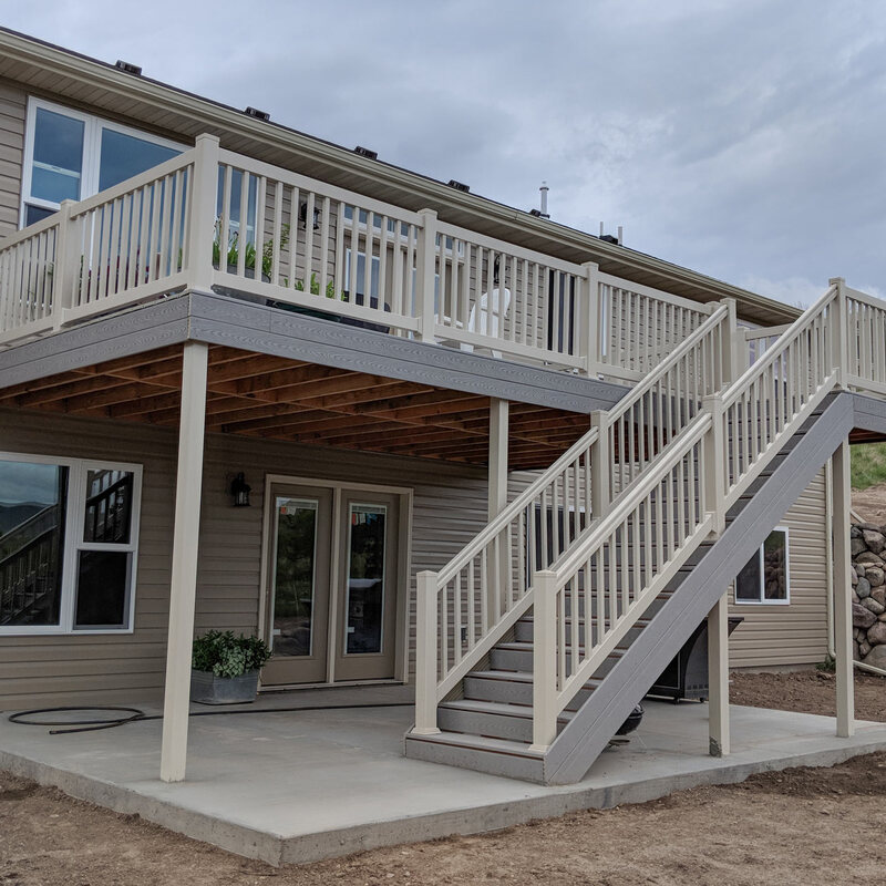 Expand your outdoor living space with this multi-level composite deck and patio combination by DeckPro LLC. This design provides a clean upper-level platform for dining and entertaining, connected by a wide, durable staircase to a lower-level concrete patio. Perfect for homes with walk-out basements, this project maximizes functionality while maintaining stunning, open views.