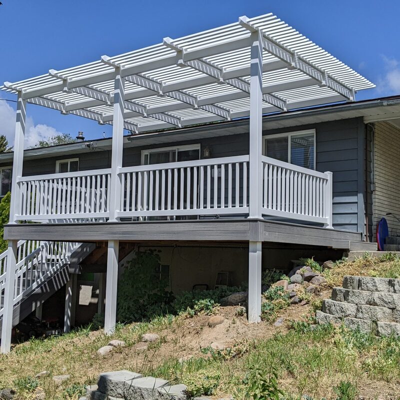 Expand your outdoor living possibilities with this custom deck by DeckPro LLC, which combines rustic elements with modern materials. We installed low-maintenance composite decking in a warm brown tone and paired it with a unique railing system that features natural wood posts and integrated wire mesh infill panels. For the ultimate in functional design, we included extensive built-in L-shaped bench seating, creating a cozy and inviting perimeter perfect for taking in scenic views.