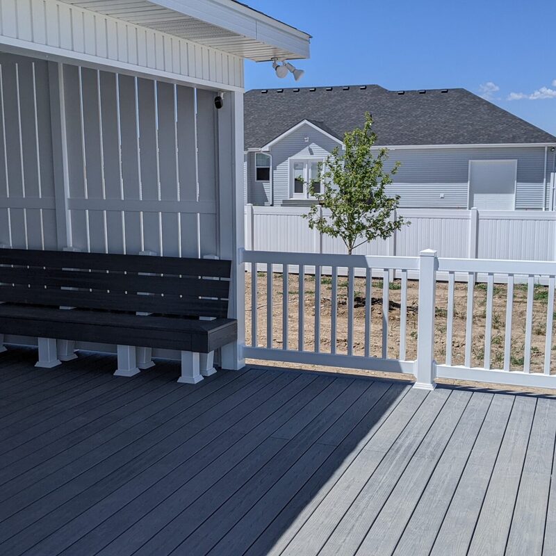 Expand your outdoor living possibilities with this extensive multi-level deck project by DeckPro LLC. We installed high-quality, low-maintenance composite decking in a modern grey tone and paired it with sophisticated dark metal perimeter railings. This functional retreat seamlessly integrates with the house’s unique architecture, featuring massive connecting stairs to a lower patio area, defined sun and shade zones, and a vast and inviting sanctuary perfect for relaxation and large-scale entertaining. Direct access is available via existing sliding glass doors, while recessed lighting in the covered sections makes indoor-outdoor living effortless, even at night.
