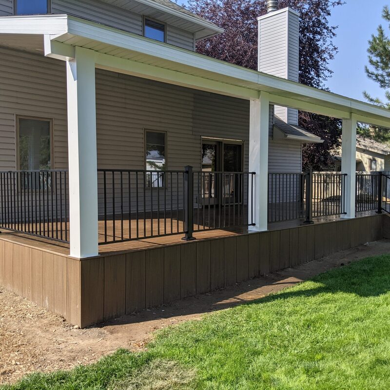 Extend your multi-level outdoor living with this expansive composite deck and patio transformation by DeckPro LLC. We took a multi-story home with rough grading and turned it into a sophisticated, multi-functional sanctuary perfect for large-scale entertaining or tranquil relaxation. Pictured on a beautiful partly cloudy day, this massive structure features multiple defined conversation areas on raised grey composite planks and safe, dark vertical perimeter railings. Direct access points via existing glass doors on multiple levels allow for effortless flow.