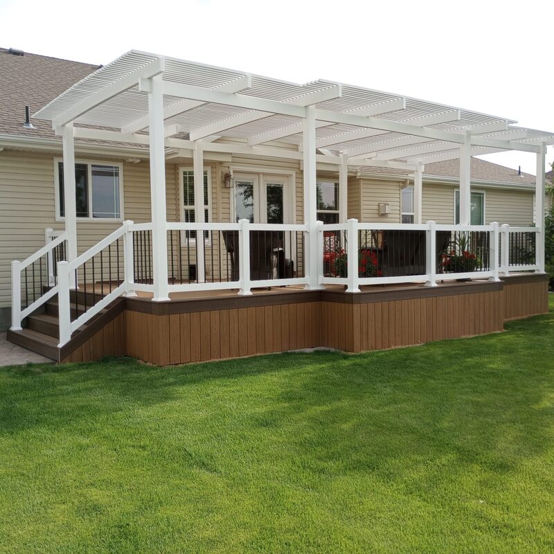 Extend your multi-level outdoor living with this expansive composite deck by DeckPro LLC. We installed high-quality, low-maintenance composite decking and paired it with safe and sophisticated black perimeter railings to ensure safety without obstructing views. Pictured on a beautiful partly cloudy day, the structure transitions via dramatic, massive, wide staircases to a stamped concrete lower level. Defining functional areas with comprehensive stairs and large potted plants, this sturdy retreat maximizes multi-directional natural views for a unique tranquillity sanctuary. Direct access is available via multiple existing sliding glass doors, while recessed lights in the under-deck ceiling allow for effortless evening use.
