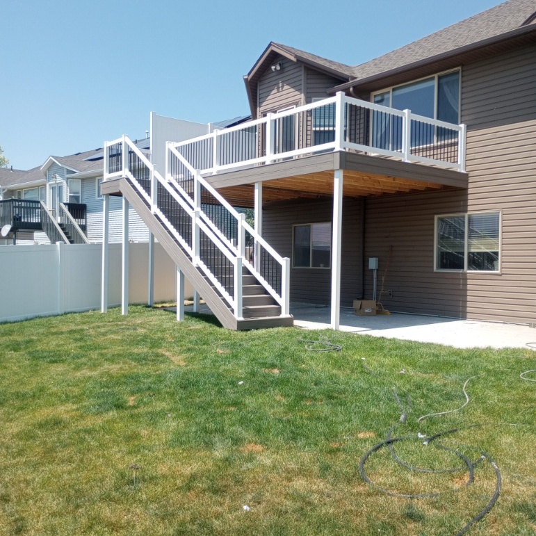 Expand your outdoor living possibilities with this dramatic before and after transformation by DeckPro LLC. We took a multi-story beige stucco house with rough dirt work and an unfinished pool area and created a luxurious, multi-functional composite deck and stone patio oasis. Pictured on a beautiful sunny day, the 'After' image reveals an extensive multi-level raised composite deck with covered areas, a custom louvered roof pergola, integrated storage, and a beautiful new natural stone patio, all surrounding a restored in-ground pool. The sturdy and sophisticated design, complete with black metal railings, offers defined zones perfect for swimming, sunbathing, dining, and relaxation in a private, tree-lined sanctuary.